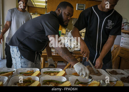 17 mars 2016 - DJ Kev (centre) et Roberto 'News'' Smith (à droite) prep livraison Les commandes à Compton en Californie. Malachie 'Spank'' Jenkins, aÂ Crip, et Roberto 'News'' Smith de la Pirus (Sang) a commencé la cuisine piège les gangs de L.A. en 2013, après avoir rencontré grâce à des amis communs et qui veulent aller legit. Ils ont renoncé à frapper des gangs et le trafic de drogue d'exécuter leur restaurant souterrain à partir d'un petit home cuisine, offrant des repas comme à la Compton pour les quartiers et les communes limitrophes du centre-sud de Los Angeles. Le piège Cuisine (un piège à House, un terme argotique utilisé pour crack h Banque D'Images