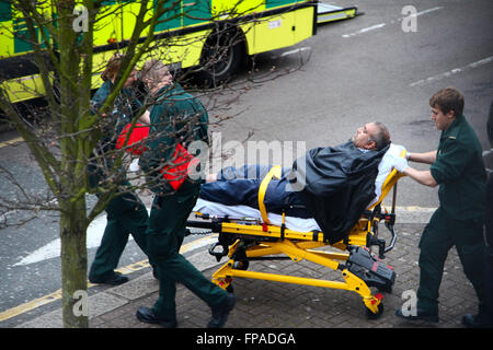 Les ambulanciers wheeling patient sur une civière dans une ambulance dans un quartier résidentiel du nord de Londres Banque D'Images