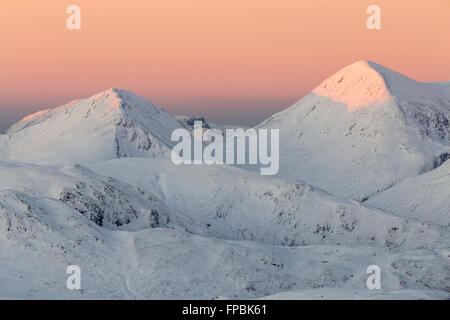 Alpenglow au lever du soleil sur un Beinn Sgritheall recouvert de neige de Sgurr Mhic Bharraich pendant l'hiver Banque D'Images