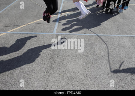 Les élèves sauts pendant les périodes de jeu au Red Hall Junior School à Darlington, comté de Durham, Royaume-Uni. Banque D'Images