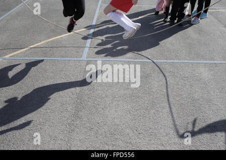 Les élèves sauts pendant les périodes de jeu au Red Hall Junior School à Darlington, comté de Durham, Royaume-Uni. Banque D'Images