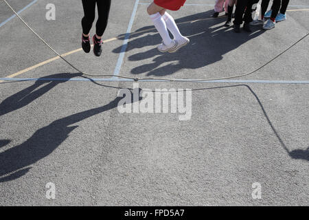 Les élèves sauts pendant les périodes de jeu au Red Hall Junior School à Darlington, comté de Durham, Royaume-Uni. Banque D'Images