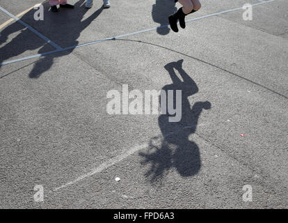 Les élèves sauts pendant les périodes de jeu au red hall junior school à Darlington, comté de Durham, Royaume-Uni. Banque D'Images