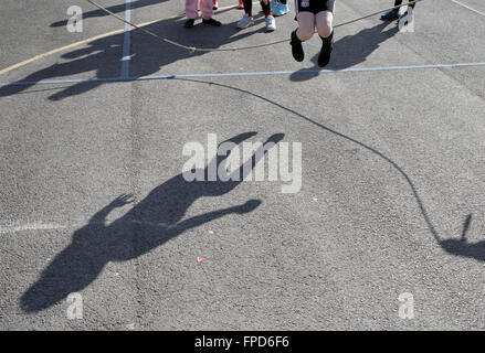 Les élèves sauts pendant les périodes de jeu au Red Hall Junior School à Darlington, comté de Durham, Royaume-Uni. Banque D'Images