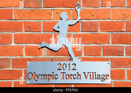 Commémorant les Jeux Olympiques de 2012 à Londres Village Torche fixe la plaque de mur d'une école à Lyndhurst dans nouvelle zone forestière de Hampshire England UK Banque D'Images