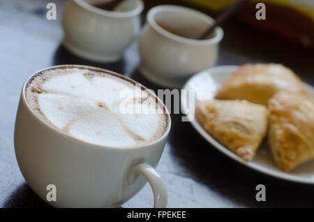 Une tasse de café chaud et Curry Puff Banque D'Images