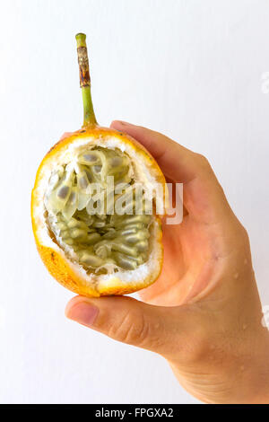 Fruit de la passion d'une tenue à la main d'une jeune femme, isolé sur blanc. Banque D'Images