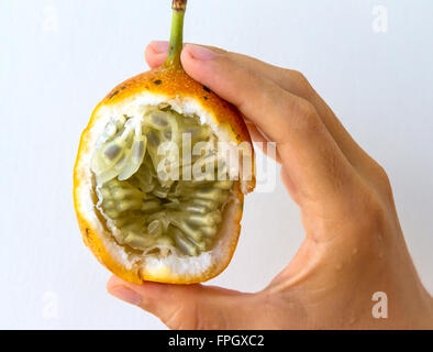 Fruit de la passion d'une tenue à la main d'une jeune femme, isolé sur blanc. Banque D'Images