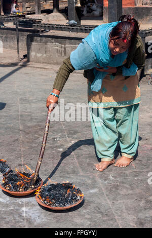 Le Népal, Patan. Femme et adorateur Fire offerts au temple hindou. Banque D'Images