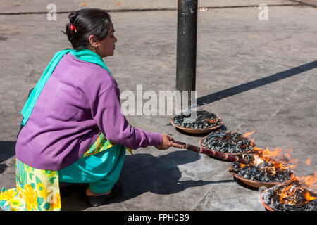 Le Népal, Patan. Femme et adorateur Fire offerts au temple hindou. Banque D'Images