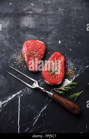 Les viandes fraîches pavé de rumsteak et fourchette à viande sur fond de marbre noir Banque D'Images