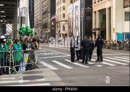 Parler de la police avant le début de la parade de la Saint-Patrick à New York, avec les spectateurs à la recherche sur. Banque D'Images