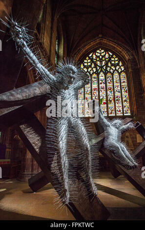 Art religieux de la crucifixion Jésus-Christ; exposition de l'église chrétienne de Noël à Chester, Cheshire, trois sculptures géantes en métal du nom de Golgotha faites de poutres en acier et des milliers de cintres en treillis métallique ont été exposées à la cathédrale. Les personnages religieux sont l'œuvre de l'artiste britannique et nominé au Prix Turner David Mach. Une équipe de spécialistes a pris cinq jours pour installer l'œuvre figurative argentée dans le transept sud du XIVe siècle de la cathédrale. Le sculpteur Mach, a déclaré : « la sculpture piqueuse est dramatique. C’est une scène épique et violente. » Banque D'Images