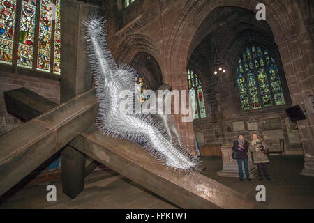 Art religieux de la crucifixion Jésus-Christ; exposition de l'église chrétienne de Noël à Chester, Cheshire, trois sculptures géantes en métal du nom de Golgotha faites de poutres en acier et des milliers de cintres en treillis métallique ont été exposées à la cathédrale. Les personnages religieux sont l'œuvre de l'artiste britannique et nominé au Prix Turner David Mach. Une équipe de spécialistes a pris cinq jours pour installer l'œuvre figurative argentée dans le transept sud du XIVe siècle de la cathédrale. Le sculpteur Mach, a déclaré : « la sculpture piqueuse est dramatique. C’est une scène épique et violente. » Banque D'Images