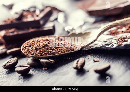 Le chocolat. Chocolat noir. Quelques cubes de chocolat noir. Plaques de chocolat râpé déversés par le chocolat en poudre. Les grains de café. Banque D'Images