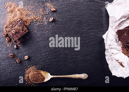 Le chocolat. Chocolat noir. Quelques cubes de chocolat noir. Plaques de chocolat râpé déversés par le chocolat en poudre. Les grains de café. Banque D'Images