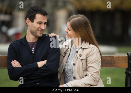 Young couple having conversation romantique après l'amour lutte sur le banc dans un parc à Paris, France Banque D'Images