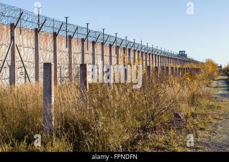 Mur de la prison et forte sur le fil barbelé enroulé dans le temps d'automne Banque D'Images