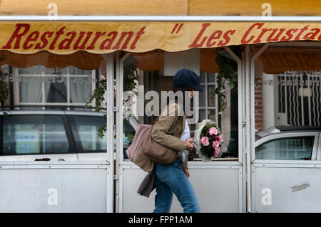 Food court de la rue Sainte-Catherine et de St Gery, Bruxelles, Belgique. Une fille marche avec des fleurs à côté de l'aire de restauration de la rue Sainte-Catherine un Banque D'Images