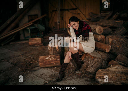 Femme assise sur le sol en bois de sciage, heureux, Banque D'Images