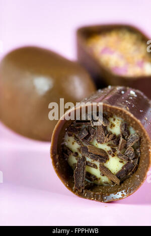 Close up of continental de luxe ou belge chocolats assortis sur fond rose Banque D'Images