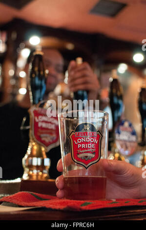 Fuller's Brewery London Pride Pint sur comptoir bar par détenu par client. Banque D'Images