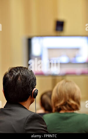 À l'aide de personnes méconnaissables dans l'oreille d'écouteurs pour la traduction pendant l'événement Banque D'Images