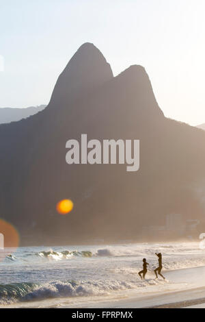 Les habitants de Rio de Janeiro entrent dans la mer sur la plage d'Ipanema Banque D'Images