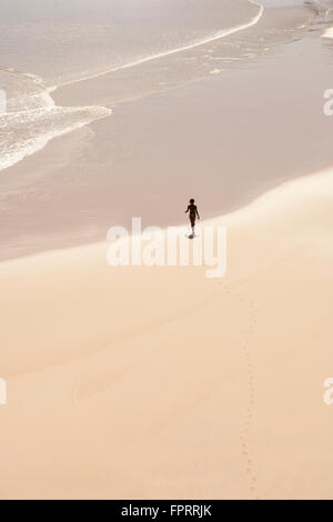 Figure dans un paysage. Une jeune femme sur une plage tropicale déserte sur l'île Fernando de Noronha au Brésil Banque D'Images