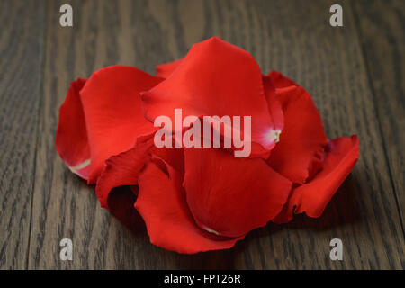 Pétales de rose rouge sur la table en bois Banque D'Images