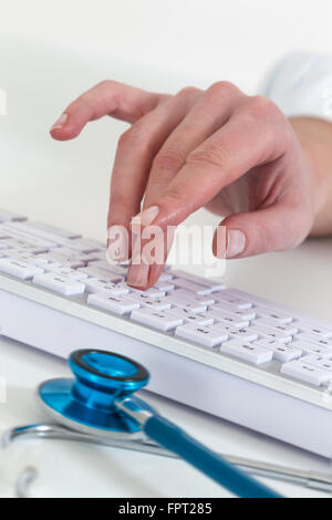 Près d'un médecin femme taping sur clavier Banque D'Images