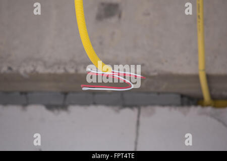 Les tuyaux en PVC jaune pour les boîtes électriques et les câbles enterrés sur mur de béton at construction site Banque D'Images