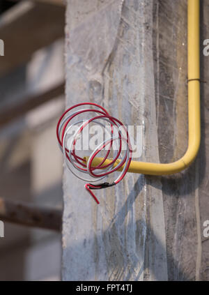 Les tuyaux en PVC jaune pour les boîtes électriques et les câbles enterrés sur mur de béton at construction site Banque D'Images