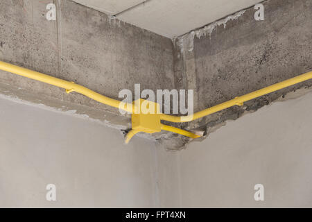 Les tuyaux en PVC jaune pour les boîtes électriques et les câbles enterrés sur mur de béton at construction site Banque D'Images