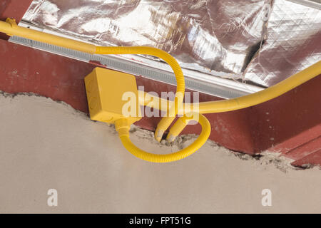 Les tuyaux en PVC jaune pour les boîtes électriques et les câbles enterrés sur mur de béton at construction site Banque D'Images