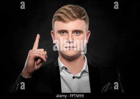 Jeune homme montre doigt vers le haut. Banque D'Images