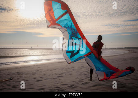 Jeune homme avec kiteboard la marche sur la plage, Viana do Castelo, Portugal, région Norte Banque D'Images