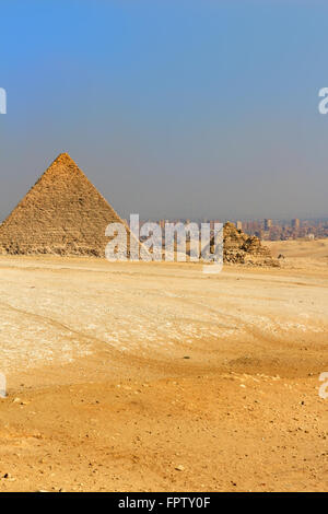 Les Pyramides de Gizeh, aménagement de l'ancienne Egypte dans le sable doré du désert pollué avec le Caire dans le background Banque D'Images