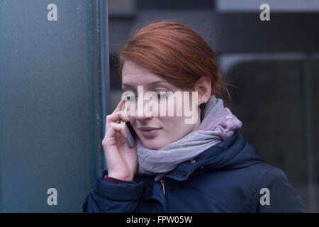 Jeune ingénieur en conversation sur un téléphone mobile près de l'appareillage dans une industrie, Freiburg im Breisgau, Bade-Wurtemberg, Allemagne Banque D'Images