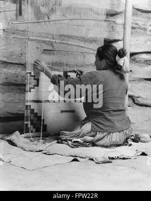 1930 NATIVE AMERICAN NAVAJO femme assise au tissage tisser un tapis Banque D'Images