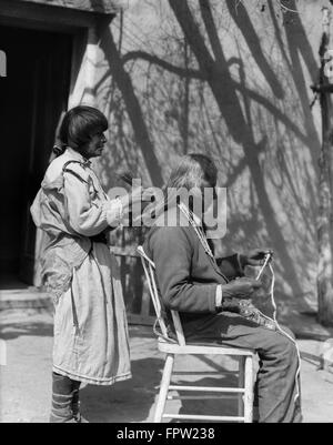 1930 Native American Woman peigner les cheveux d'un homme âgé avec peigne de Cochiti Pueblo NOUVEAU MEXIQUE USA Banque D'Images