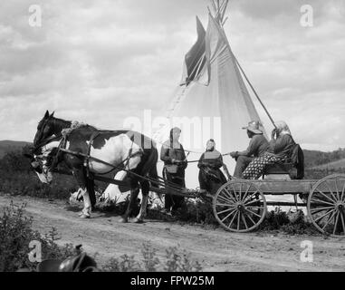 Années 1920 DEUX Native American Indian DES COUPLES VISITANT PAR TEPEE UN COUPLE SUR CHEVAL ET UNE CHARRETTE TRIBU SIOUX STONEY ABLERTA CANADA Banque D'Images