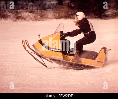 1970 WOMAN DRIVING COURSE EN MOTONEIGE SKIDOO JAUNE Banque D'Images