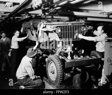 1940 SALARIÉS DE LA DÉFENSE DE LA LIGNE DE MONTAGE AUTOMOBILE DROP CORPS SUR BLITZ CHÂSSIS BUGGY JEEP FORD USINE DE RIVER ROUGE DETROIT MI USA Banque D'Images
