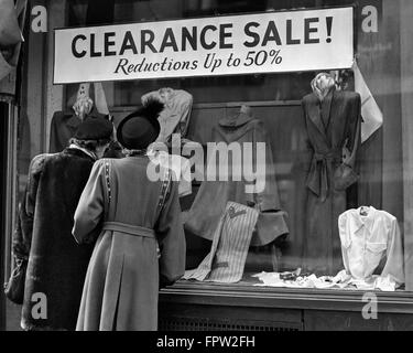 Années 50, DEUX FEMMES BACK VIEW WINDOW SHOPPING SUR MADISON AVENUE STORE SOLDES LIQUIDATION 50 % de réduction NEW YORK USA Banque D'Images