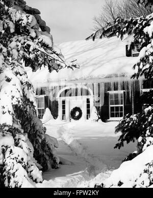 1960 PAR LA NEIGE EN HIVER MAISON TOIT GLAÇONS PENDANT DE PORTE AVANT AVEC COURONNE DE NOËL Banque D'Images