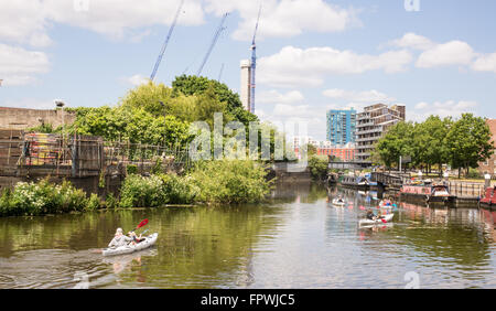 Groupe de quatre kayakistes urbain canotage sur la rivière lea dans l'Est de Londres menant à la Tamise. Banque D'Images