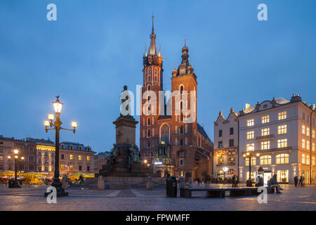 La nuit commence à la basilique Sainte-Marie église sur la place principale du marché, en vieille ville de Cracovie, Pologne. Banque D'Images