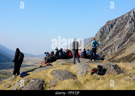 Un groupe de marcheurs se reposer et ejoying la vue vers le bas le Nant Ffrancon passent dans le Snowdonia avec Pen An Wen Ole mountain. Banque D'Images