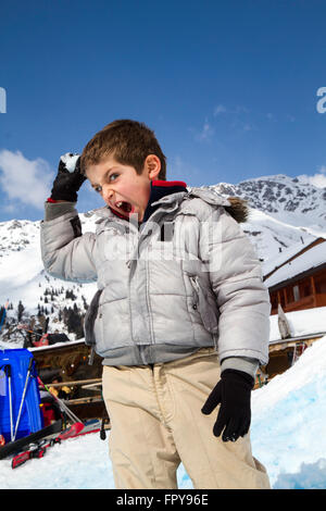 Close up enfant tirant snowball avec fond de ciel bleu Banque D'Images